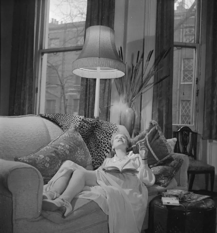 Wartime promotional image showing a glamorous woman reclining with a book and smoking a cigarette